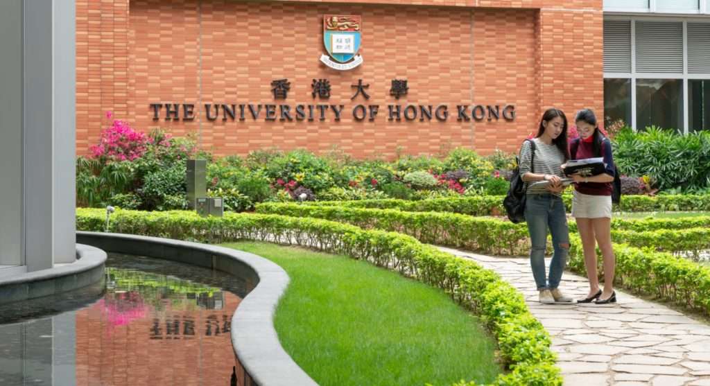 Junket Education Hong Kong three Singapore Two Study Abroad Service, their students stand in front of the University of Hong Kong's academic building, discussing the content of their studies.